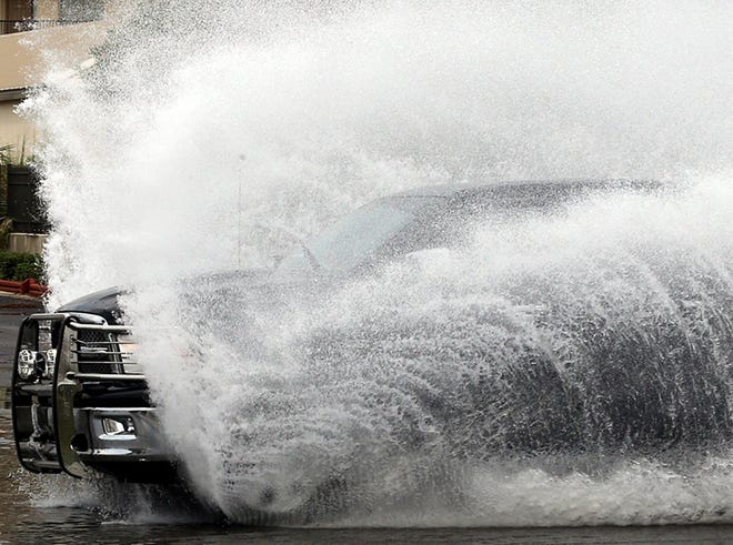 A truck blasts through standing water on Thomas Drive in Panama City Beach on Thursday.