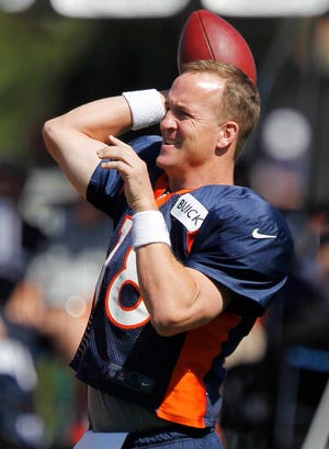 Denver Broncos quarterback Peyton Manning warms up during NFL football training camp in Englewood, Colo., on Friday, Aug. 2, 2013. (AP Photo/David Zalubowski)