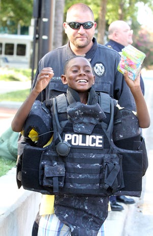 Shelby Police Sgt. Chris Howington shows Kamarree Jefferies a ballistic vest at a National Night Out in Shelby. (Star file photo)