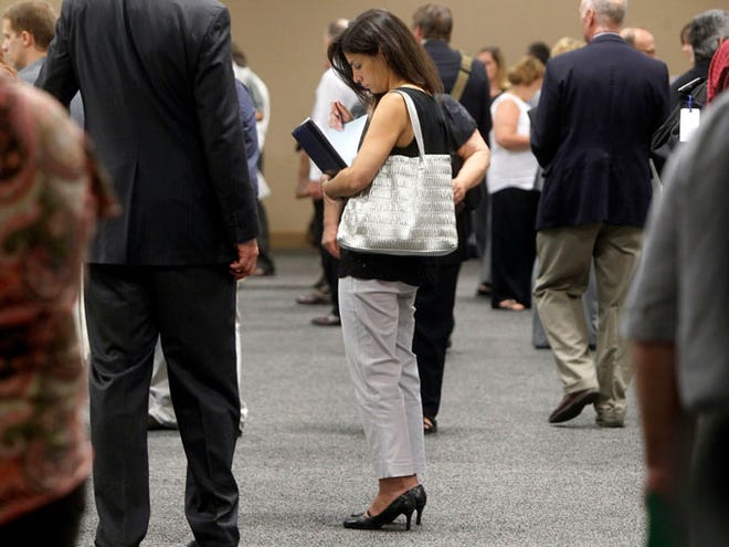 In this Monday, July 15, 2013 file photo, a woman waits to talk with employers at a job fair for laid-off IBM workers in South Burlington, Vt. The government issues the jobs report for July on Friday, Aug. 2, 2013. (AP Photo/Toby Talbot, File)