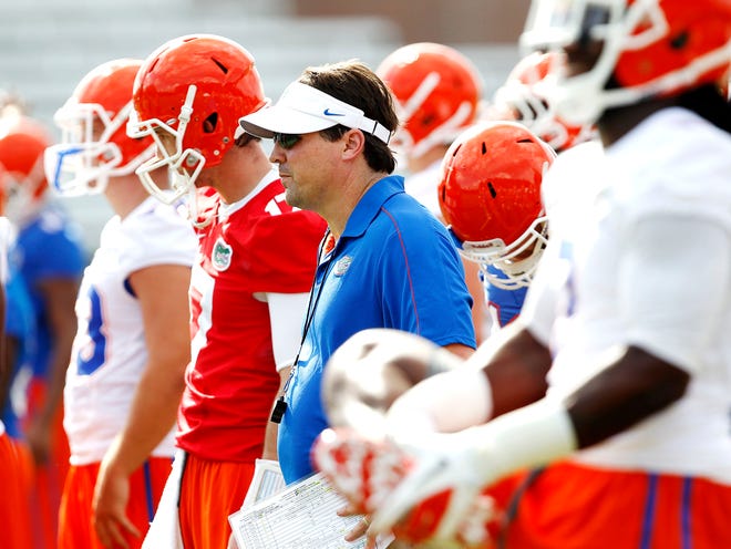 Florida coach Will Muschamp watches as his team runs a drill during the first day of practice at Donald R. Dizney Stadium on Friday.