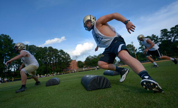 Williams High School players run through drills Thursday during the first official day of prep football practice in North Carolina.