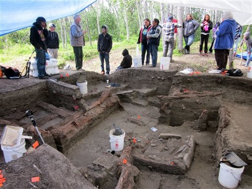 In this July 18, 2013 image provided by Alaska Public Radio Network, Dr. Doug Anderson, third from left, an Archaeologist with Brown University, speaks to residents from the nearby village of Kiana, Alaska about the ruins of a large, pre-contact Alaska Native Village that he and his team have uncovered along the banks of the Kobuk River. Anderson estimates about 200 people lived in the village, which he believes was a regional capital. Researchers think the village dates from the late 1700s to the early 1800s, just before initial contact with explorers. (AP Photo/Alaska Public Radio Network, Daysha Eaton)