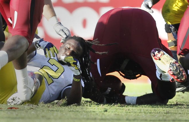 Michigan's Vincent Smith loses his helmet as South Carolina's Jadeveon Clowney recovers the fumble on the hard hit in the fourth quarter in the Outback Bowl in Tampa, Florida on Tuesday Jan 1, 2013. JULIAN H. GONZALEZ/Detroit Free Press