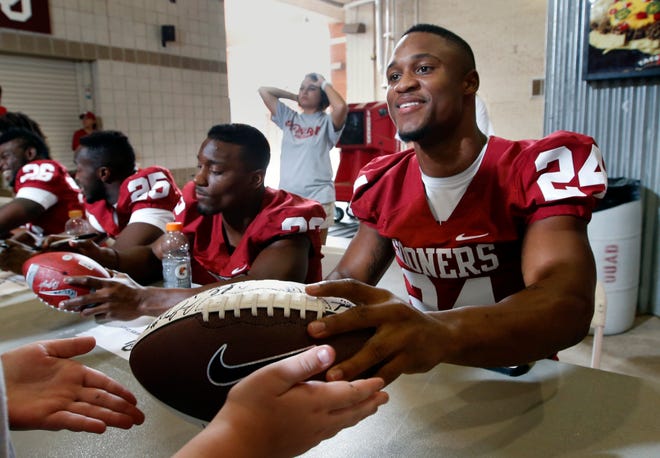 Runningback Brennan Clay signs autographs during fan appreciation day for the University of Oklahoma Sooner (OU) football team at Gaylord Family-Oklahoma Memorial Stadium in Norman, Okla., on Saturday, Aug. 3, 2013. Beside him is Roy Finch. Photo by Steve Sisney, The Oklahoman