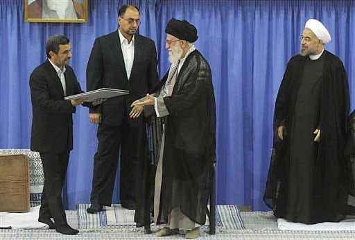 In this picture released by the official website of the Iranian supreme leader's office, outgoing President Mahmoud Ahmadinejad, left, delivers the official seal of approval of Supreme Leader Ayatollah Ali Khamenei, center, to give to President-elect Hasan Rouhani, right, in an official endorsement ceremony, in Tehran, Iran, Saturday, Aug. 3, 2013. Iran's supreme leader has formally endorsed Hasan Rouhani as president opening the way for the moderate cleric to take over from outgoing President Mahmoud Ahmadinejad. An unidentified official of the supreme leader's office stands at second left.