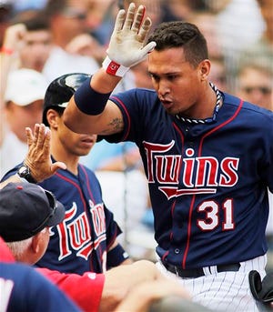 Minnesota Twins Oswaldo Arcia is congratulated after hitting a solo home run in the 7th inning off Houston Astros pitcher Brad Peacock during their baseball game won by the Twins 3-2 in Minneapolis, Sunday, Aug. 4, 2013.