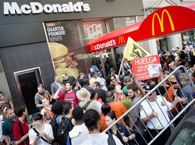 Demonstrators in support of fast food workers protest outside a McDonald's as they demand higher wages and the right to form a union without retaliation Monday, July 29, 2013, in New York's Union Square. Activists say hundreds of workers have walked off their jobs. They are demanding a minimum wage increase and calling for better benefits.