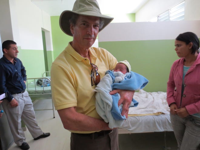 Dr. Alan Berrick of Hingham holds a newborn baby delivered by a woman at the hospital in the town of Constanza in the Dominican Republic. Berrick, a Quincy cardiologist, was part of the latest Constanza Medical Mission in May.