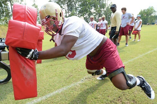 Elon defensive lineman Jay Brown hits a sled during Monday’s first day of practice for the Phoenix.