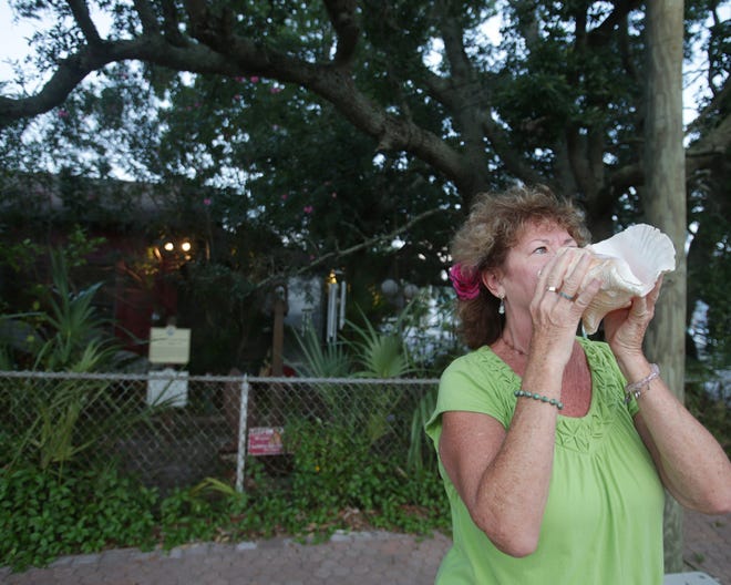 Mary Lou Smith, the "Queen of Conch," blows her conch shell Tuesday outside the Panama City home of Bill "Cap'n Scuba" Tant, her friend for 12 years, who died Friday. Tant blew his conch shell every day at sunset, said Smith, and he taught her the conch-blowing tradition.
