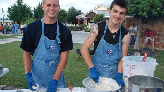 Cody Grohman, left, and James Dunn make biscuits by hand for the Bastrop Homecoming & Rodeo Cowboy Breakfast this past Saturday.
