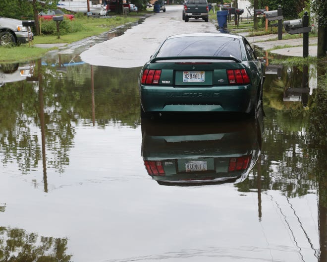A car sits on a flooded street in Panama City on July 5. The Panhandle received more than a foot of rain in some spots, including Bay County.