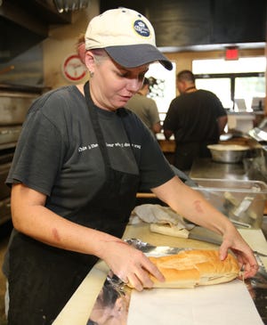 Meredith McCranie prepares a sub in the kitchen at Brooklyn's Original Pizzeria on Northeast 14th Street. The restaurant is moving south, into the site formerly occupied by The Copper Pot.