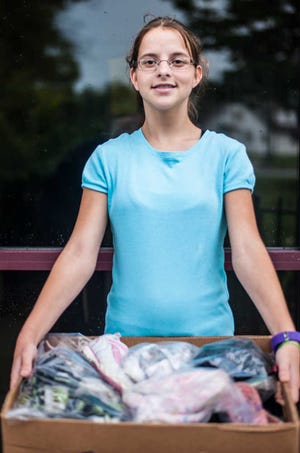 Jocelyn Schini, 13, holds a box of shoes Wednesday outside Faith Mission in Elkhart, Ind. She and her mother, Amy, organized the drive to provide shoes for orphaned children.