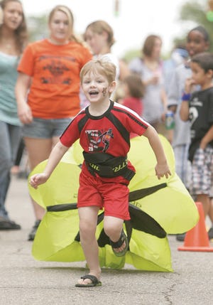 Six-year-old Samuel Hawthorne of Massillon tries out the parachute run as part of the Massillon track and cross country team's obstacle course.