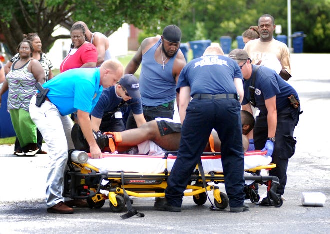 Havelock Fire and EMS and Havelock Police Officers help a shooting victim onto a gurney Friday afternoon at Kelly Park Apartments. The victim was shot by another man who fled the scene. Police are investigating.