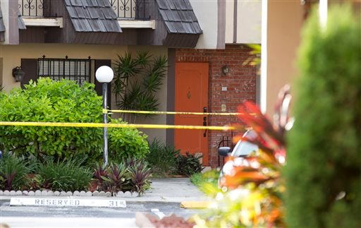 Police tape blocks the entrance to a murder scene in Miami Thursday. Derek Medina, who authorities say fatally shot his wife — and apparently then posted a photo of her body on Facebook — turned himself in to police on Thursday.