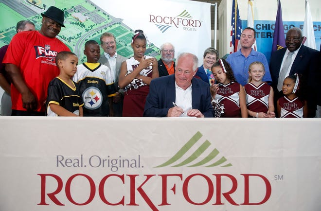 Area youth and dignitaries gather around Gov. Pat Quinn as he signs the Reclaiming First bill Saturday, Aug. 10, 2013, at the Chicago Rockford International Airport in Rockford.