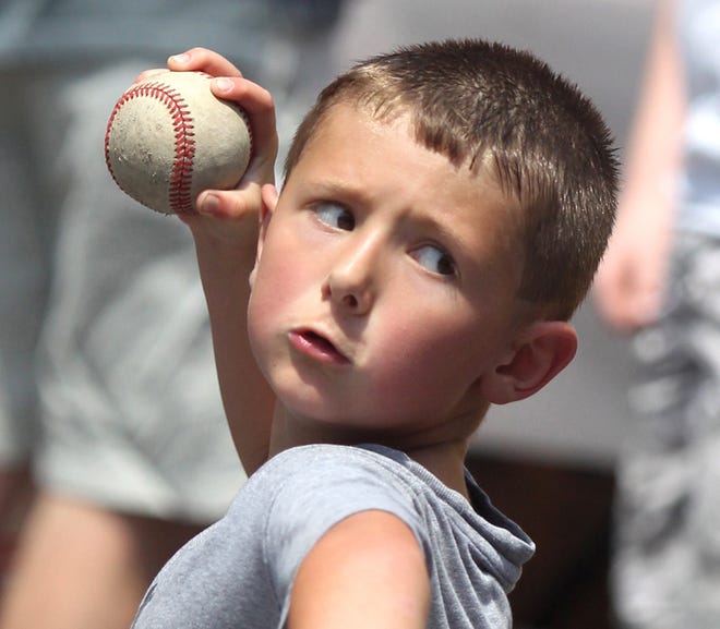 Zach Scott, 7, gets ready to toss a baseball for a game at the 7th Inning Stretch Festival on Saturday.