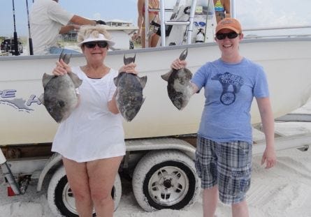 Chris Sawyer (left) of Knoxville, Tenn., and Megan Swett of Decatur, Ga., show off some of the triggerfish they caught Wednesday morning aboard Capt. Tyler's Charters out of Grayton Beach.