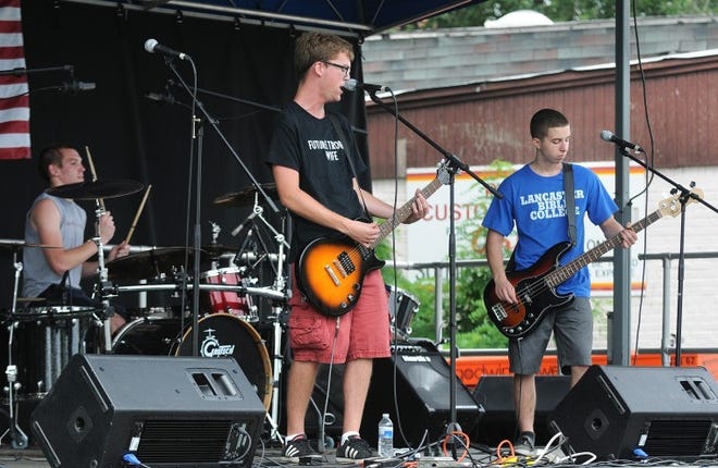 Members of the band "Final Warning" play on the main stage at Hollystock in downtown Mount Holly on Saturday afternoon. Left to right are Joe Cicchino on drums, Chris Ulyett on guitar, and Vince DeBlasio on bass guitar.