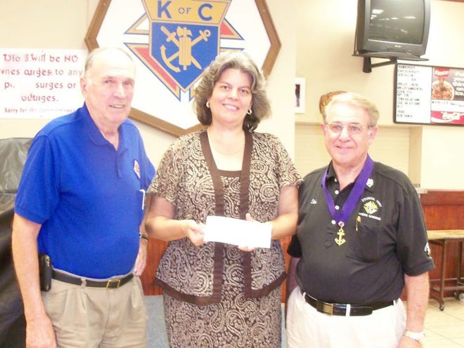 Nancy Woolcock accepts a check on behalf of Polk County Special Olympics from Bob Nelson, Knights of Columbus Council 7091's charity chairperson, and Grand Knight Sal Porta, who chaired the council's Tootsie Roll drive, which was the funding source for this donation. 
(PROVIDED TO THE LEDGER)