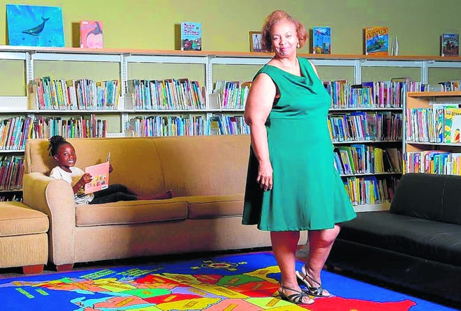 Alice McCloud, the new librarian at North Sarasota Library, stands in the 
library's youth reading room on Tuesday. Six-year-old Jamariah Williams is 
at left. STAFF PHOTO / ELAINE LITHERLAND