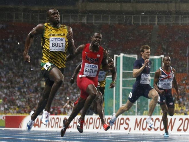 Jamaica's Usain Bolt, left, crosses the finish line to win the gold in the Men's 100-meter final ahead of USA's Justin Gatlin, center, at the World Athletics Championships in the Luzhniki stadium in Moscow, Russia, Sunday, Aug. 11, 2013. (AP Photo/Matt Dunham)