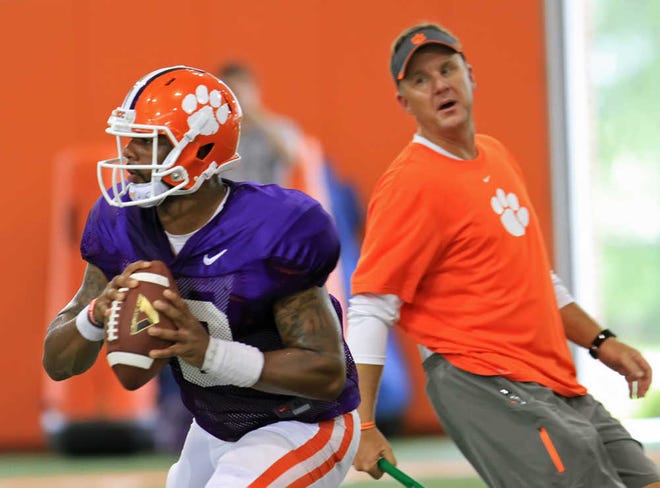 Clemson quarterback Tajh Boyd, left, rolls out after being pressured by offensive coordinator and quarterbacks coach Chad Morris during NCAA college football practice Wednesday, Aug. 7, 2013 in Clemson, S.C. (AP Photo/Anderson Independent-Mail, Mark Crammer)