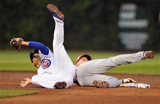 Chicago Cubs' Darwin Barney, left, tumbles and holds on to the ball to tag out the Cincinnati Reds' Devin Mesoraco at second base during the third inning of a baseball game, Monday, Aug. 12, 2013, in Chicago. (AP Photo/Jim Prisching)