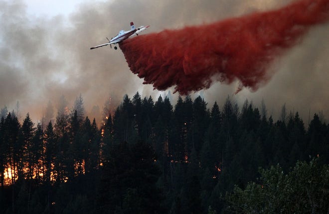 An air tanker drops fire retardant on the hillside overlooking Pine, Idaho while battling the more than 80,000 acres Elk Complex FIre on Sunday Aug.11, 2013. (AP Photo/Times-News,Ashley Smith) Mandatory Photo Credit