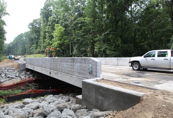 Contractors work on the new Island Creek bridge in Jones County Tuesday. The bridge, which has been under construction since June, was scheduled as a 60-day project, but has been delayed by weather and other concerns. It is expected to open Monday evening.