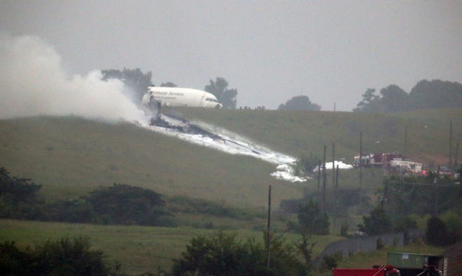 A UPS cargo plane lies on a hill at Birmingham Shuttlesworth International Airport after crashing on approach, Wednesday, Aug. 14, 2013, in Birmingham, Ala. An airport spokeswoman says the large UPS cargo plane that crashed went down in an open field just outside an airport in Birmingham, Ala. (AP Photo/Hal Yeager)