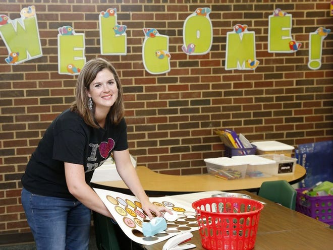 Nikki McCurtain, a fourth-grade teacher for Plaza Towers Elementary, decorates her class for an open house to be held in the evening at the school's temporary location at Central Junior High school, in Moore, Okla., on Wednesday. Classes begin today for the students who lost their school in the May 20 tornado. 
(Sue Ogrocki | THE ASSOCIATED PRESS)