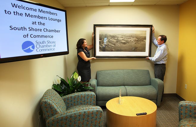 The South Shore Chamber of Commerce is settling in to it's new location at 1050 Hingham St. in Rockland. Chief Operating Officer Laurel Kenny and President and CEO Peter Forman hang an engraving of the Fore river Shipyard before WWII in the Members Lounge Friday, August 2, 2013.
Gary Higgins/The Patriot Ledger