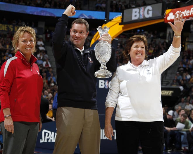 In this Feb. 7, 2013 file photo, Mike Whan, center, commissioner of the LPGA, holds up the trophy for The Solheim Cup while U.S. Team Capt. Meg Mallon, right, and assistant captain Dottie Pepper, a former Sarasota resident, look on as the three are introduced in the second quarter of an NBA basketball game between the Chicago Bulls and the Denver Nuggets in Denver.