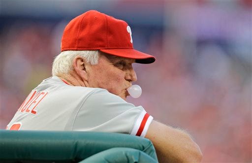 Philadelphia Phillies manager Charlie Manuel (41) blows a chewing gum bubble as he keeps his eye on a baseball game during the third inning against the Washington Nationals at Nationals Park, Saturday, Aug. 10, 2013, in Washington. (AP Photo/Alex Brandon)