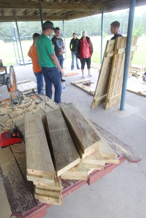Marines and volunteers take a break from building picnic tables during a Day of Action at Dixon Middle School recently.