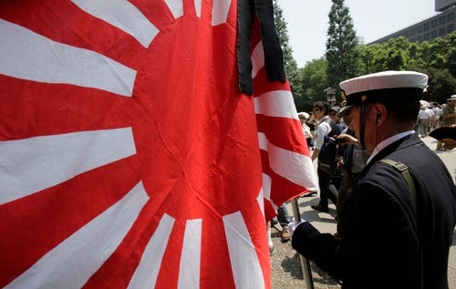 THE ASSOCIATED PRESS
A Japanese man clad in a navy uniform holds a Japanese military flag as he pays respect to the nation's war dead at the Yasukuni Shrine in Tokyo on Thursday, Aug. 15, 2013. Japan marked the 68th anniversary of its surrender in World War II with somber ceremonies Thursday and visits by senior politicians to the shrine honoring 2.5 million war dead that remains a galling reminder of colonial and wartime aggression. (AP Photo/Shizuo Kambayashi)
