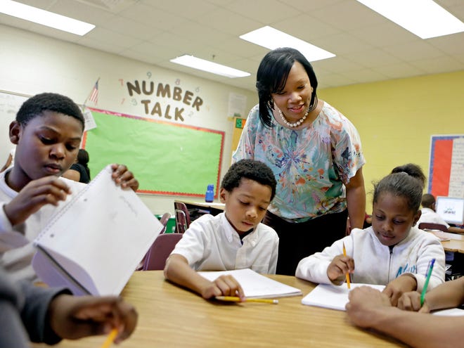 In this April 18, 2013, file photo, Burgess-Peterson Elementary School principal Robin Robbins, center, meets with students during an after-school study program in Atlanta, in preparation for state standardized testing, soon to begin. A new poll from the Associated Press-NORC Center for Public Affairs Research finds parents of school-age children view standardized tests as a useful way to track student progress and school quality. Most parents say their own children are given about the right number of standardized tests, according to the AP-NORC poll. And almost three quarters say they favor changes that would make it easier for schools to fire poorly performing teachers.