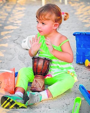 Lilly Price, 2, has fun drumming on her mini djembe at the drum circle on 
Holmes Beach.