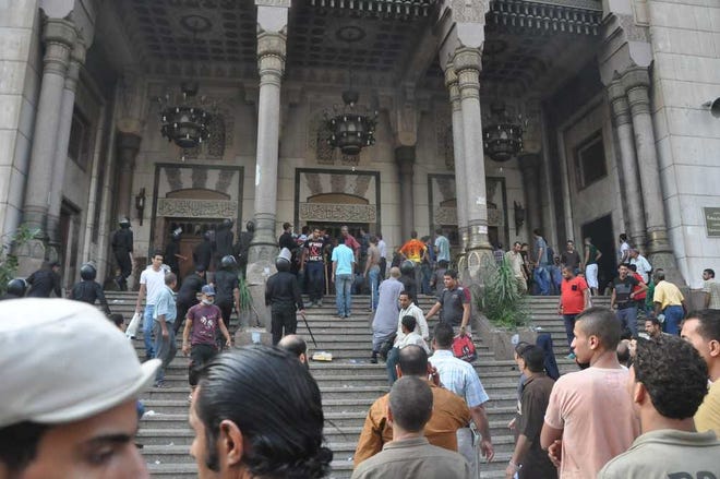 Egyptians gather at the al-Fatah mosque after hundreds of Muslim Brotherhood supporters barricaded themselves inside the mosque overnight in Cairo, Egypt, following a day of street battles that left scores of people dead.