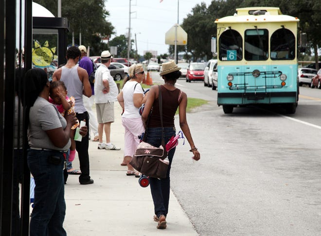 Passengers wait to board a trolley as it arrives at Gulf Coast State College in Panama City.