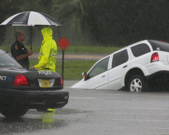 Police officers work the scene of a partially submerged SUV at the Panama City Mall in Panama City on Saturday.
