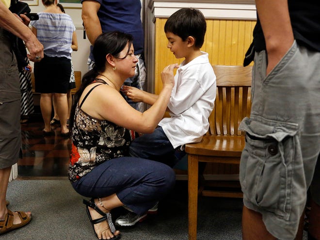 Maria Herrera shares a moment with her son, Santiago Layton, 7, before he goes to his first-grade class on the first day back to school at J.J. Finley Elementary School in Gainesville on Monday.