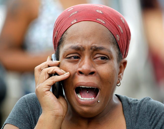 Nicole Webb cries as she talks on a phone in the parking lot of a store while waiting for her 9-year-old son, a student at Ronald E. McNair Discovery Learning Academy in Decatur, Ga., on Tuesday, Aug. 20, 2013. Superintendent Michael Thurmond says all students at the school east of Atlanta are accounted for and safe and that he is not aware of any injuries. (AP Photo/John Bazemore)
