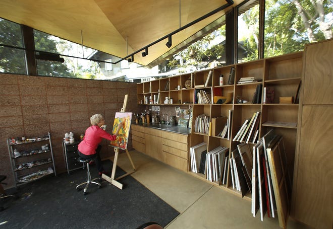 Gwen Freeman paints in an art studio designed by architect Rick Corsini. Corsini designed a modern detached studio to complement the existing 1908 Craftsman main house.