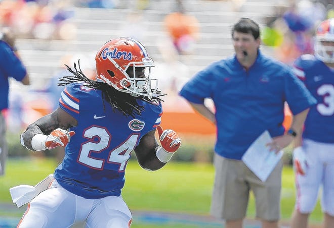 Florida running back Matt Jones runs though a drill under the watchful eye 
of head coach Will Muschamp, right, during a spring practice and scrimmage 
in Gainesville. The Gators' top running back has not practiced this summer 
due to a viral infection. ASSOCIATED PRESS / JOHN RAOUX