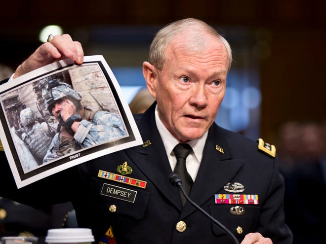 In this July 18, 2013, file photo, Gen. Martin Dempsey, chairman of the Joint Chiefs of Staff, holds up a photo of a deployed American soldier as he testifies before the Senate Armed Services Committee at his reappointment hearing, on Capitol Hill in Washington.